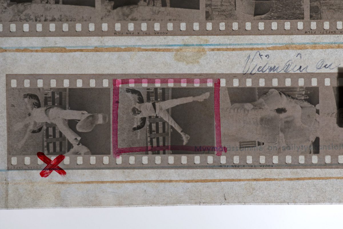 I en mapp har turvis förvarats filmremsor och hastigt gjorda kontaktkopior. Till följd av materialens kemiska samverkan är tuschmärkningarna på väg att tränga igenom skyddspapperet och färga av sig på filmerna. Bild: Tiina Oasmaa / JOKA