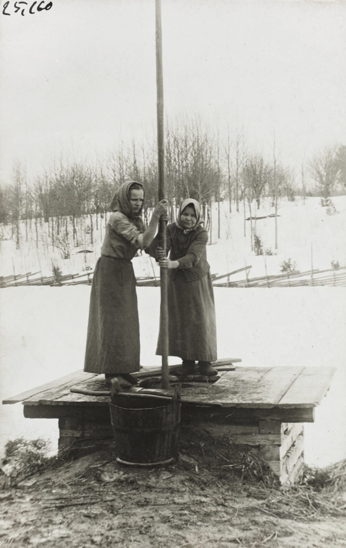 Kvinnor tar upp vatten ur en brunn med en stång i byn Airanne i Sordavala landskommun i början av 1900-talet.​ Foto: Liina Cantell / Karelska nationens samling / Museiverkets Bildsamlingar