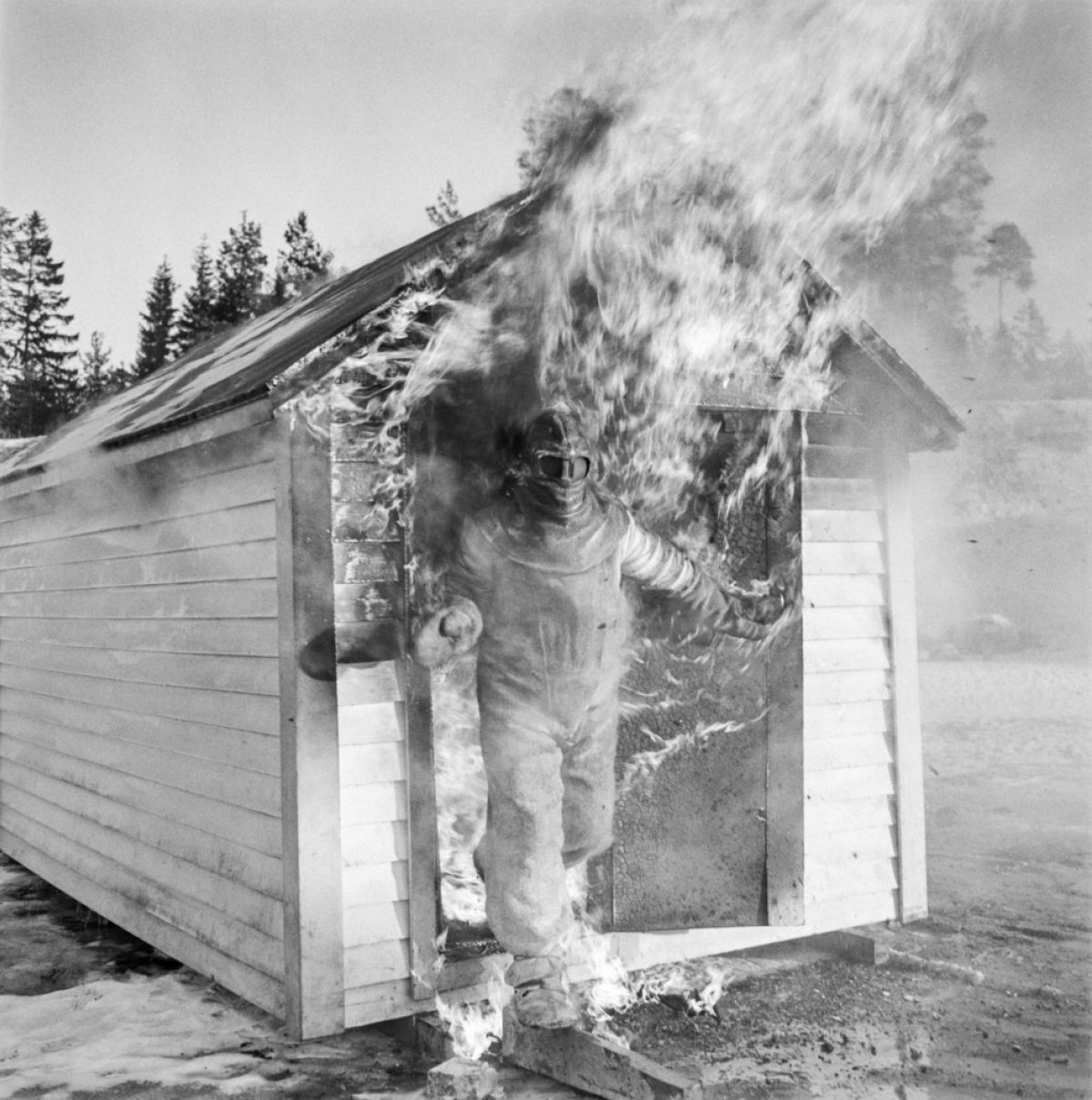 Matti Jämsä kokeili Suomen Mineraali Oy:n asbestipuvun käyttöä vuonna 1957. Hän viivytteli liekkien keskellä niin kauan, että avustajat pelkäsivät pahinta. Kuva: UA Saarinen / JOKA / Museovirasto